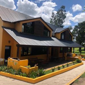 a house with a metal roof on top of it at Cabañas Rocas in Tandil