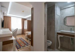 a bathroom with a toilet and a sink at Elit Lara Otel in Salihli