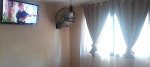 a tv hanging on a wall next to a window at Vergniaud 70 in Colón