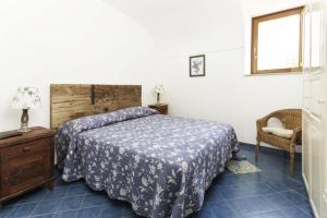 a bedroom with a bed and a chair at La Cantina in Ventotene