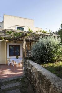 a house with a stone wall and a table at La Cantina in Ventotene
