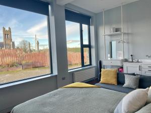 a bedroom with a bed and two large windows at School house Portaferry in Portaferry