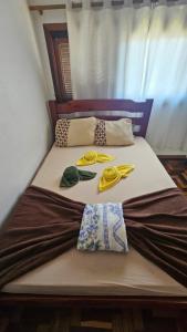 a bed with two pillows and hats on it at Tranquilidade a 4 minutos da praia - Com Estacionamento Rotativo in Tramandaí