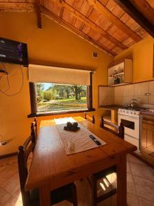 a kitchen with a wooden table and a window at Cabañas Rocas in Tandil
