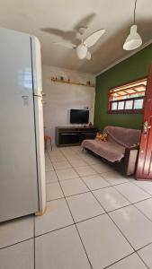 a living room with a refrigerator and a tv at Tranquilidade a 4 minutos da praia - Com Estacionamento Rotativo in Tramandaí