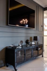 a black entertainment center with a television on a wall at Czantoria View Apartment Ustroń in Ustroń