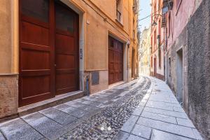 an empty alley with brown doors in a city at Casa Vacanza Pablo Castello in Cagliari