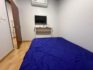 a bedroom with a blue bed and a television at Solara เฮ้าส์ in Ban Nong Saeng (4)