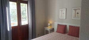 a bedroom with a bed with red pillows and a window at Gáldar-Centro in Gáldar