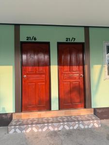 two red doors on the side of a building at Solara เฮ้าส์ in Ban Nong Saeng (4)