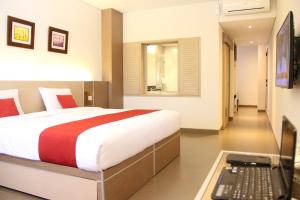 een slaapkamer met een bed en een laptop op een bureau bij Mutiara Hotel and Convention in Bandung
