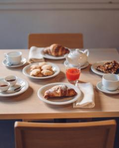 a wooden table with plates of food on it at Mistral2 Hotel in Oristano