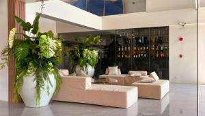 a lobby with couches and plants in a building at Cara Studio Mactan Cebu Cozy with Garden View at Primeworld District Tower H 103 in Lapu Lapu City