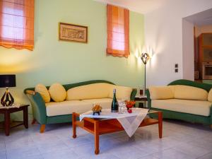 a living room with two couches and a coffee table at Villa Tzitzifies in Kouroukláta