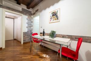 a dining room with a glass table and red chairs at Casa Vacanza Pablo Castello in Cagliari