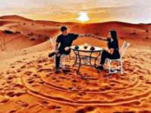 a man and a woman sitting at a table in the desert at Luxury Dune's Camp in Merzouga