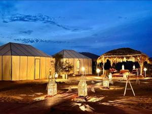 a tent with lights in front of it at night at Luxury Dune's Camp in Merzouga