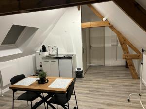 a kitchen with a table and chairs in a room at Ferme du grand treille in Haverskerque