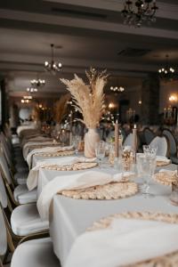 a row of tables with white table cloths on them at Miód Lawenda in Biardy