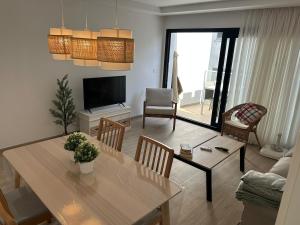 a living room with a table and a television at Arguineguín sol y playa in Arguineguín