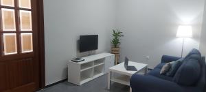 a living room with a blue couch and a tv at Gáldar-Centro in Gáldar