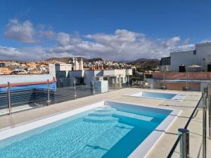 a swimming pool on the roof of a building at Arguineguín sol y playa in Arguineguín