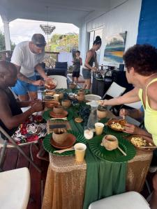a group of people sitting around a table with food at Turtle Nest Mayreau in Mayreau