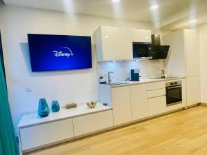 a kitchen with white cabinets and a blue sign on the wall at Ocean Front Cura Beach in Playa del Cura