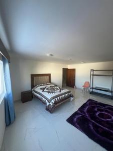 a bedroom with a large bed and a purple rug at Casa Analco Durango in Durango