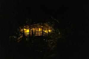 a house lit up at night with a porch at Rancho Margot Sustainable & Self Sufficient Eco Lodge in El Castillo de La Fortuna