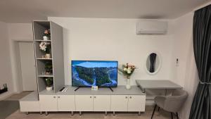 a living room with a tv on a white cabinet at Mountain View Apartment&Parking in Râşnov