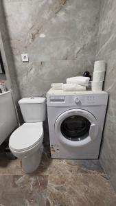 a bathroom with a toilet and a washing machine at Mountain View Apartment&Parking in Râşnov +20 photos