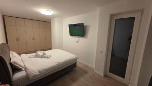 a bedroom with a bed with a teddy bear on it at Mountain View Apartment&Parking in Râşnov