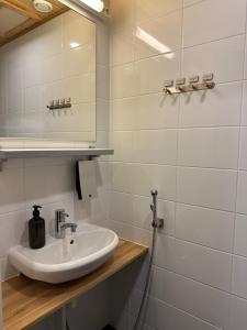 a white bathroom with a sink and a mirror at Chalets LumiHelmi 2 Ruka in Ruka +18 photos