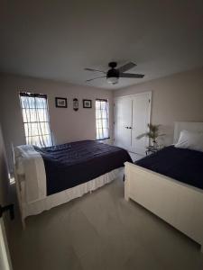 a bedroom with two beds and a ceiling fan at Sunshine house on the canal in North Fort Myers +40 photos