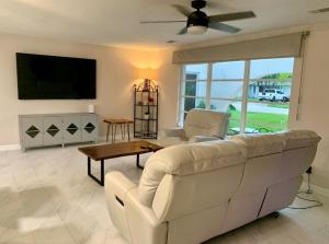 a living room with a white couch and a tv at Sunshine house on the canal in North Fort Myers
