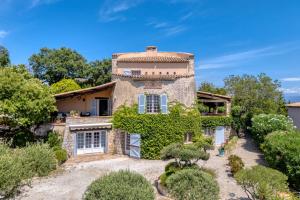 an exterior view of a stone house with ivy at Villa au calme jardin piscine proche mer et centre ville in Vallauris