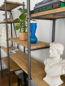 uno scaffale con una statua e un vaso sopra di Cièlo a Tongeren Altre 31 foto