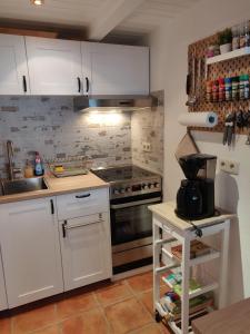 a kitchen with white cabinets and a stove at Haus-Salamander-mit-Sauna in Wildemann