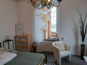 a bedroom with a bed and a chair and a window at Ferienwohnung Springstein in Aue