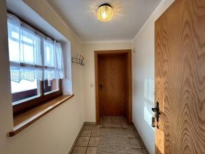 a hallway with a door and a window at Niedermaier Hof in Bad Birnbach