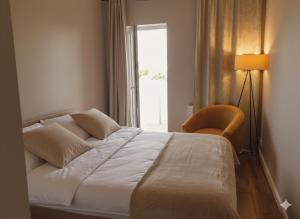 a bedroom with a bed and a chair and a window at Caskada Modern Apartments 2 NOWY APARTAMENTOWIEC WINDA in Słupsk