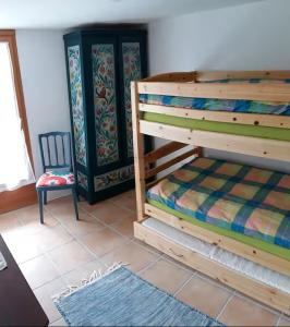 a bedroom with a bunk bed and a chair at Rustico La Stalla di Adele in Cevio
