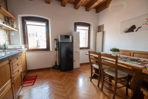 a kitchen with a refrigerator and a table with chairs at Torre Cà Emo, Il Bilocale "Leone di San Marco" in Vittorio Veneto