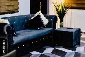 a blue couch in a living room with a table at Caroline Cozy Apartment in Accra