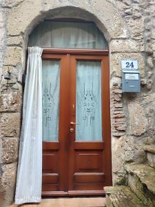 a wooden door with a window in a stone building at LA BICO' in Pitigliano