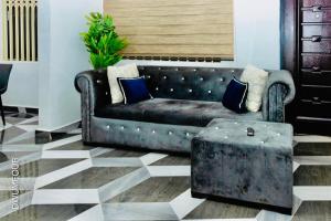 a leather couch sitting in a living room with a table at Caroline Cozy Apartment in Accra