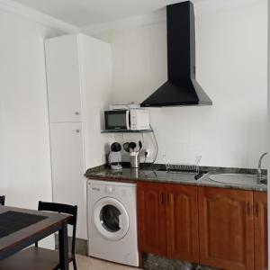 a kitchen with a washing machine and a microwave at El 20 in Barbate