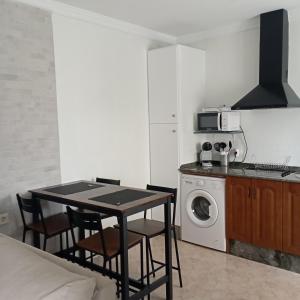 a kitchen with a table and a washing machine at El 20 in Barbate