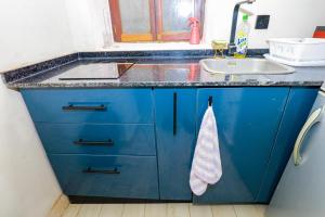 a kitchen with a sink and a blue cabinets at CoastalCharms Zanzibar in Zanzibar City